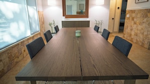 A conference room with a long table, chairs, a ceiling fan, and a wall-mounted mirror. - Gulfport Getaway - Beach, Downtown, Shops nearby (South Pasadena)