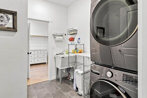 Ein kleiner Waschraum mit Waschmaschine, Wäscheständer und Waschbecken.
