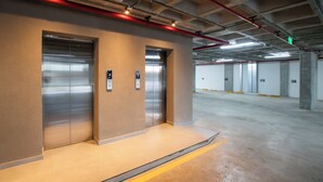A clean, modern elevator area with a metallic elevator and a wall-mounted control panel. - Corporate Stays First Living - 806 (Asunción)