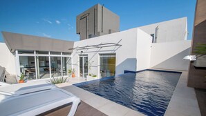 A modern outdoor pool area with a glass-enclosed patio and a lounge chair. - Corporate Stays First Living - 806 (Asunción)