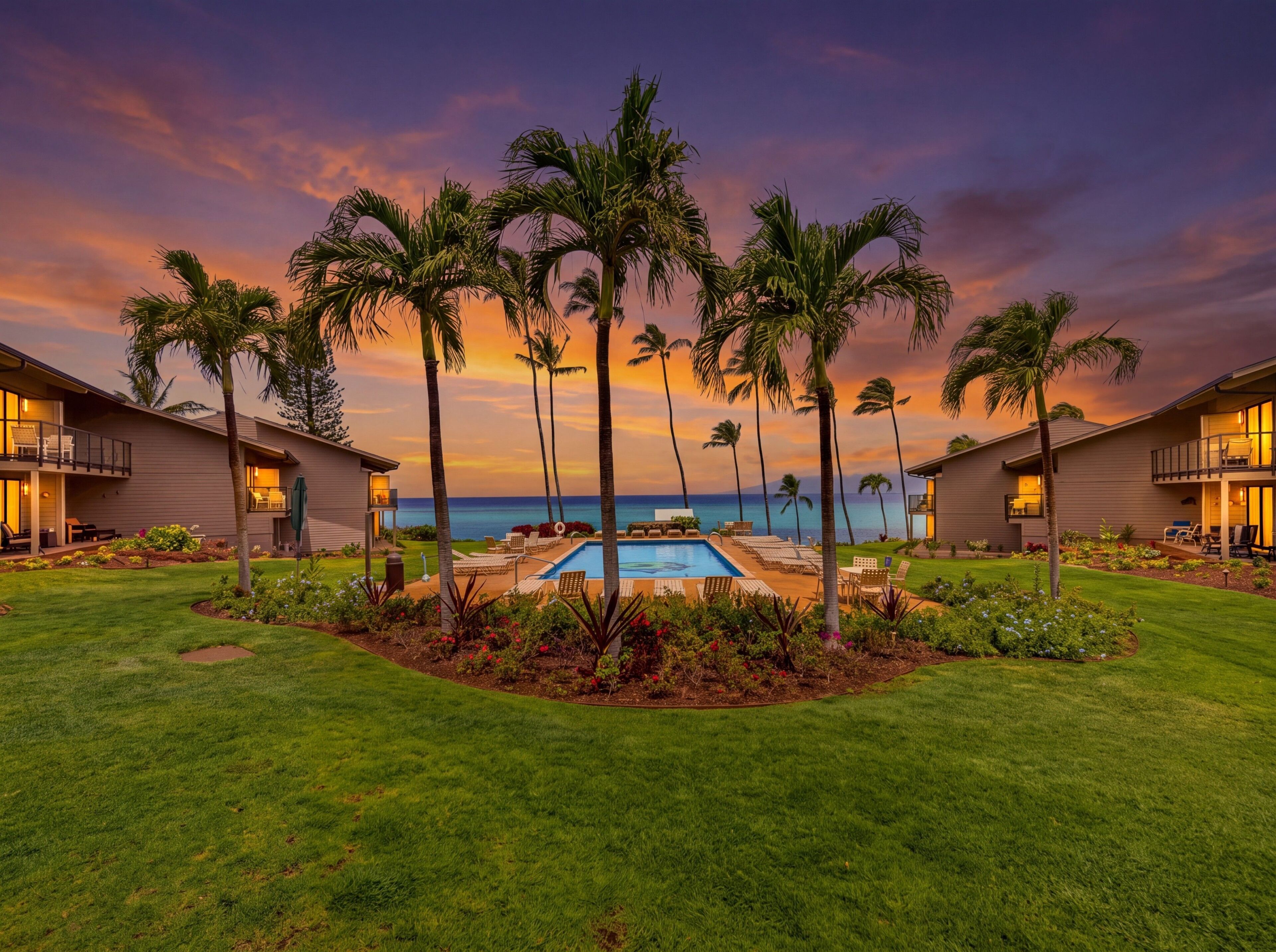 Ein Resort mit Swimmingpool, Palmen und Blick auf das Meer bei Sonnenuntergang.