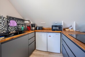 A compact kitchen with a dishwasher, a coffee maker, a toaster, and a microwave. - Chez Laetitia - A 400 m de la plage (Plougonvelin)
