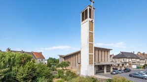 A tall, white church with a cross on top, surrounded by residential buildings and parked cars. - Vigie d'Opale - Nausicaá & plage à 700 m (Boulogne-Sur-Mer)