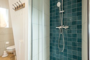 Ein Badezimmer mit Dusche, Toilette und Handtuchhalter.