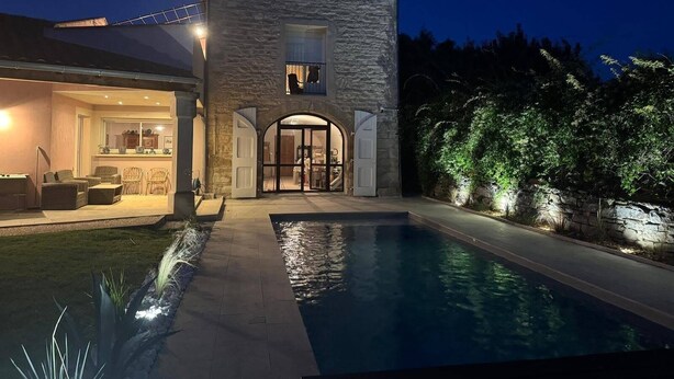 A stone building with a pool, outdoor seating, and a well-lit entrance. - La Maison Rose - Avec Piscine Privée (Barjac)