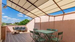 An outdoor patio area with a table and chairs, a sofa, and a ceiling fan. - La Maison Rose - Avec Piscine Privée (Barjac)