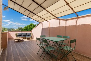 An outdoor patio area with a table and chairs, a sofa, and a ceiling fan. - La Maison Rose - Avec Piscine Privée (Barjac)