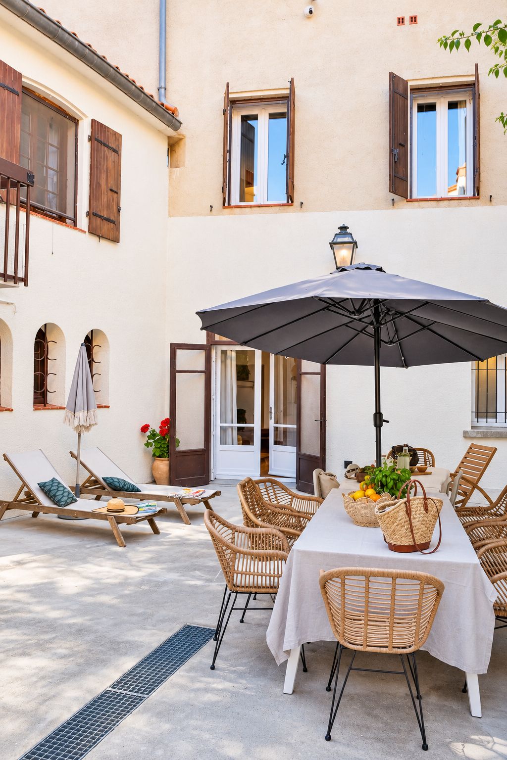 Ein Sitzbereich im Freien mit Tisch, Stühlen und Sonnenschirm.