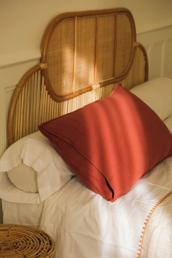 A bed with a wooden headboard, white bedding, and a red pillow. - Maison Sarava – Superior Apartment with Separate Studio & Private Patio (Espira-de-l'Agly)