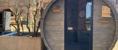 Una gran estructura de madera con una puerta, una ventana pequeña y una placa de madera.