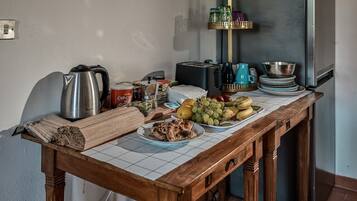 Un tavolo da pranzo con diversi cibi, elettrodomestici e utensili da cucina.