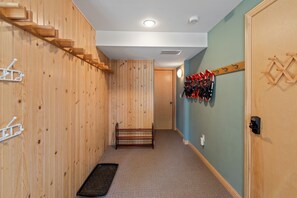 Ein Korridor mit Holzwänden, einer Bank und einem Garderobenhaken mit Ski.