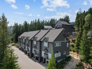 Ein mehrstöckiges Gebäude mit moderner Architektur, umgeben von dichtem Wald.