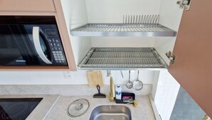 Keittiössä on mikroaaltouuni, pesuallas ja ruostumattomasta teräksestä valmistettu hylly.