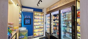 A micro market with refrigerated and non-refrigerated sections, a trash bin, and a security camera. - COCDV0103 - Edificio Alive (Salvador)