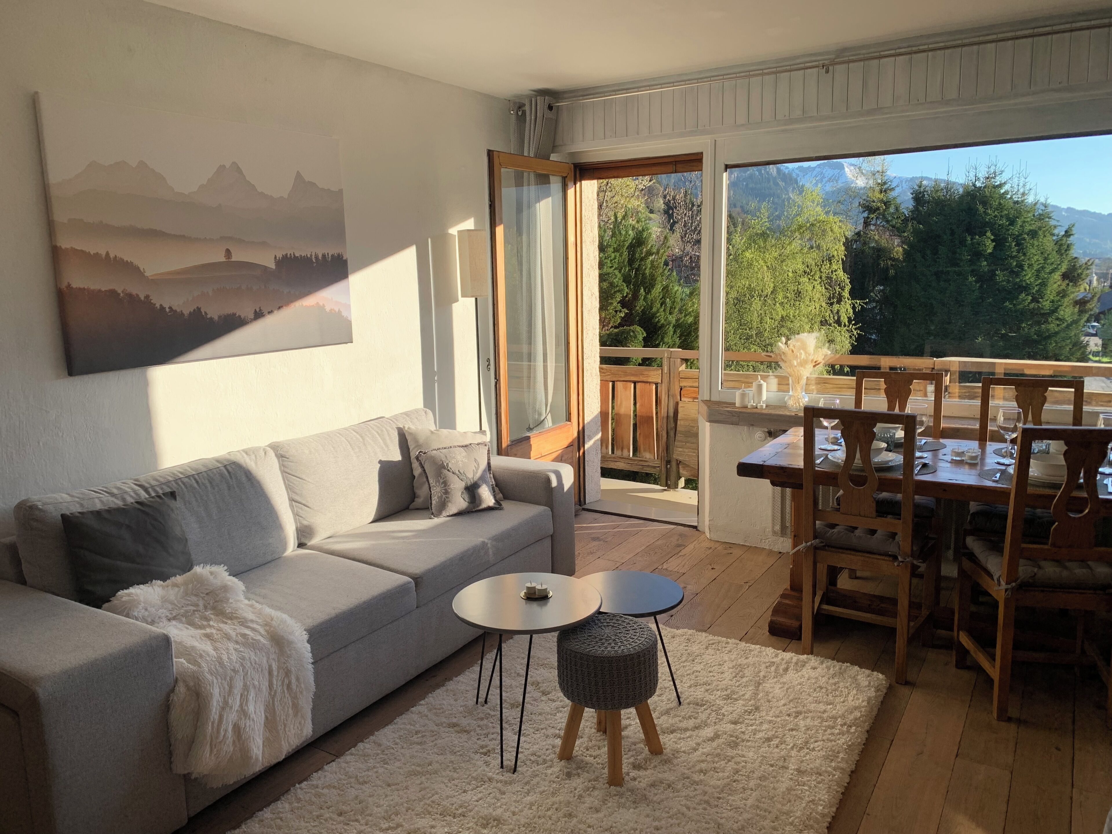 A living room with a sofa, a coffee table, and a dining area with a table and chairs.