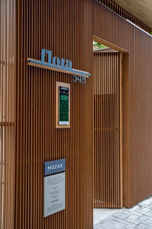 Eine Holzhaut mit vertikaler Paneelausbildung, ein Empfangstresen und ein Schild mit dem Schriftzug 'MOZAK'.