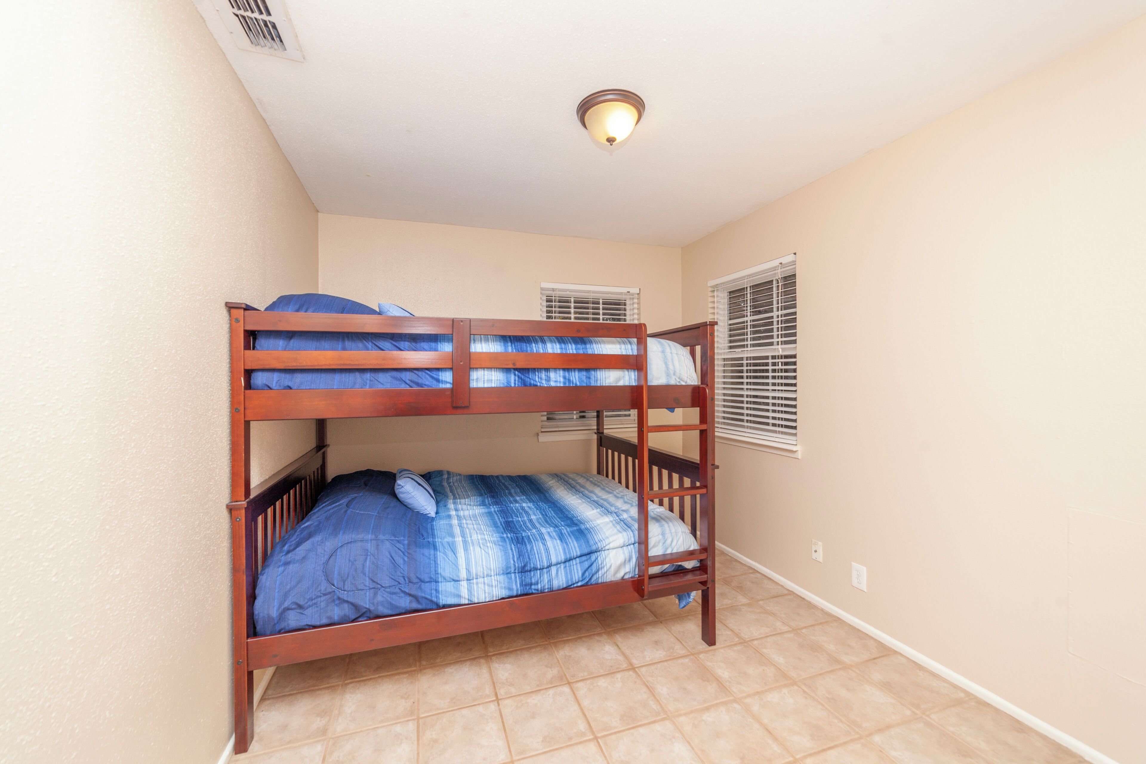 A bunk bed room with a ceiling light fixture.