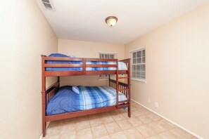 Quarto com beliche e luminária no teto.