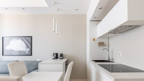 Une cuisine moderne équipée d’une cuisinière intégrée, d’un évier et d’un coin repas avec une table et des chaises.
