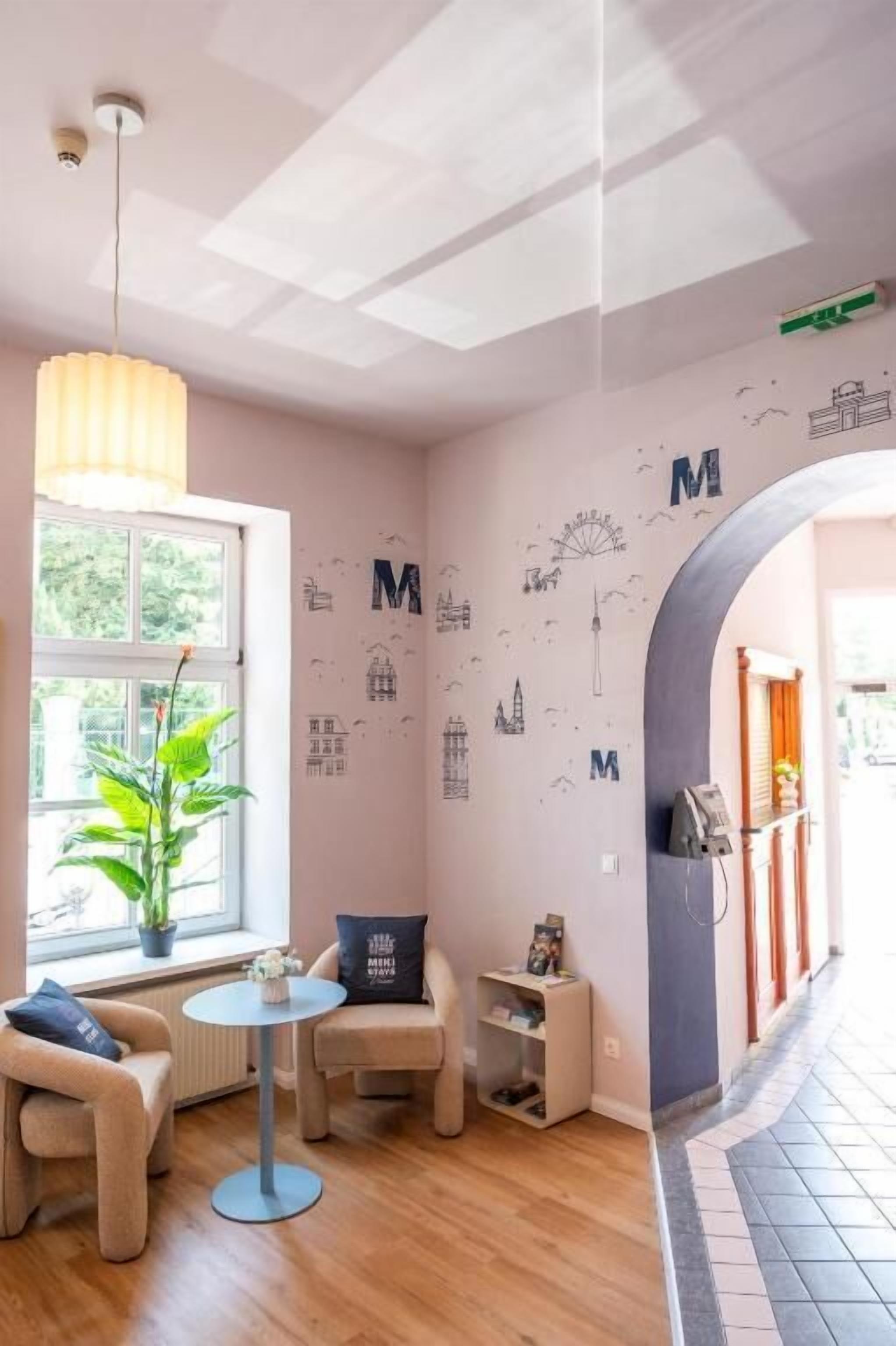 Une pièce avec une fenêtre, une plante, une table ronde et un canapé.
