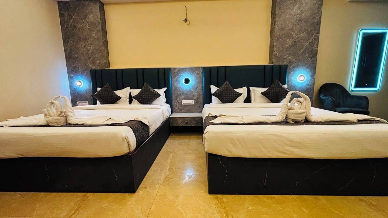 Ein Hotelzimmer mit zwei Betten, einem Marmorboden und moderner Wandbeleuchtung.