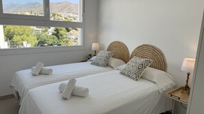 A hotel room with two beds, white linens, and a view of a mountainous landscape. - Nerja Paradise Rentals - Villa La Marea (Nerja)