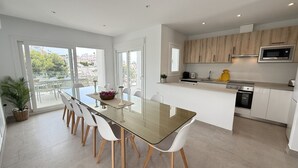 A modern kitchen with a central island, white cabinetry, and a built-in microwave. - Nerja Paradise Rentals - Villa Barranco (Nerja)