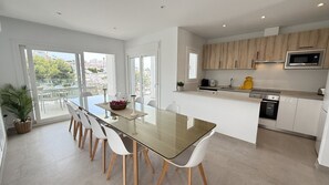 A modern kitchen with a central island, white cabinetry, and a built-in microwave. - Nerja Paradise Rentals - Villa Barranco (Nerja)