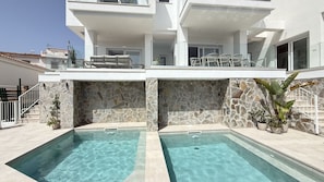 A modern building with a pool area, stone walls, and outdoor furniture. - Nerja Paradise Rentals - Villa Barranco (Nerja)