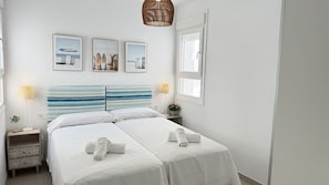 A hotel room with a bed, two bedside tables, a lamp, and wall art. - Nerja Paradise Rentals - Villa Barranco (Nerja)