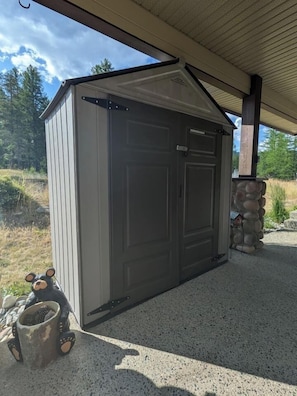 A single-story shed with a closed door, a small bear decoration, and a stone pillar. - Spacious Kimberley Mountain Retreat | 5 Bedrooms (Kimberley)