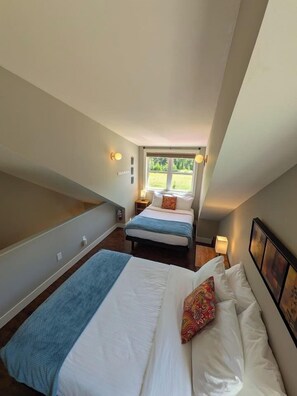A bedroom with two beds, a window, and a staircase. - Spacious Kimberley Mountain Retreat | 5 Bedrooms (Kimberley)