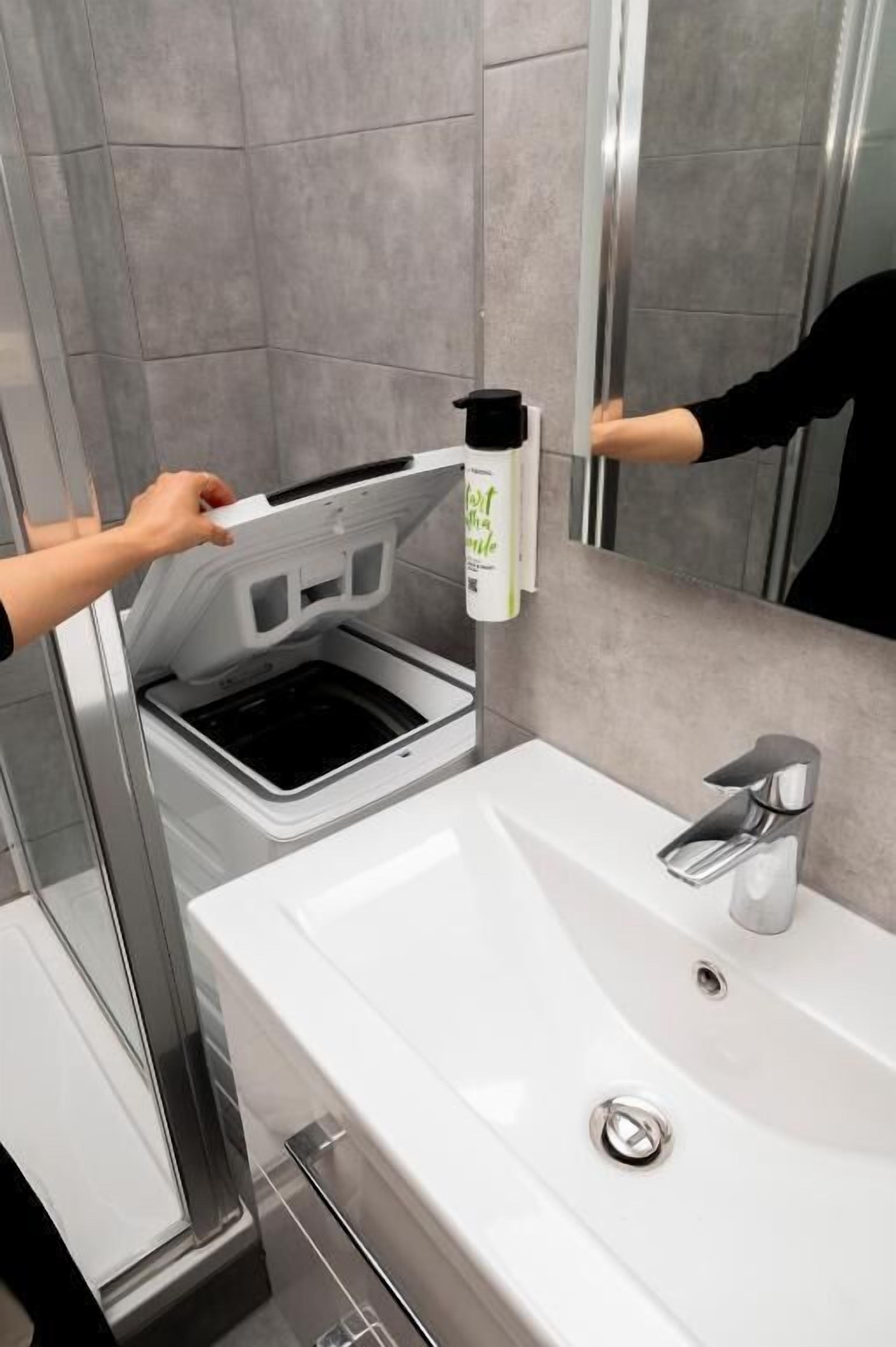 A bathroom with a white sink, a mirror, and a shower area.