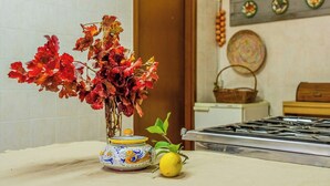 A kitchen with a vase of red leaves, a lemon, and a decorative jar on the counter. - Farmhouse with pool between Orvieto and Todi (Montecchio)