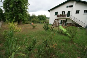 Ein Wohngebiet mit einem weißen Haus, einer Schaukel und einem kleinen Garten.