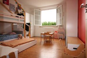 A child's bedroom with bunk beds, a desk, a chair, and a window with a view of greenery. - 100-square-meter apartment in a quiet location right in the heart of town (Saint-Pée-sur-Nivelle)