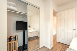 A bedroom with a bed, a television, and a sliding door leading to another room. - 35-45 Grasshopper Lane combo ·Large retreat, red rock views, spas, six king beds (Sedona)