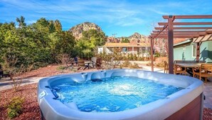 A hot tub in a backyard with a pergola, a table, and chairs. - 35-45 Grasshopper Lane combo ·Large retreat, red rock views, spas, six king beds (Sedona)