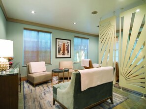 A modern hotel room with a sofa, two armchairs, a small table, and a decorative partition. - Island-Style Living with a Full Kitchen and Direct Access to Pool Near Key Largo (Duck Key)