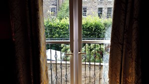 A room with a sliding glass door leading to a balcony with a metal railing.