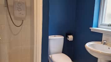 Un bagno con doccia, WC e lavandino.