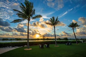 A sunset view with palm trees and chairs on a grassy lawn. - Enjoy Coastal Living with Private Pool & Kitchen Access Near Key West (Duck Key)