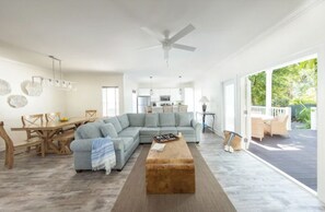 A spacious living area with a large sectional sofa, a wooden coffee table, and a dining set. - Serene Stay – Private Pool & Full Kitchen Near Key Largo (Duck Key)