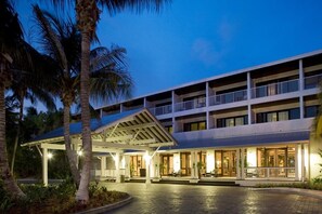 A multi-story hotel with a covered entrance and outdoor seating area. - Everything you Need for Comfort: Pool Access and Full Kitchen - Near Key West (Duck Key)