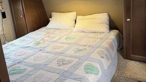 Un dormitorio con una cama, cabecera y armario.