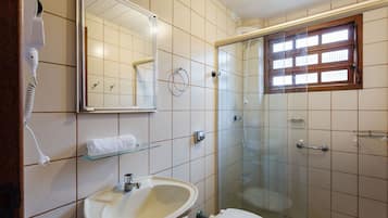 Un baño con lavamanos, inodoro y cabina de ducha de vidrio.