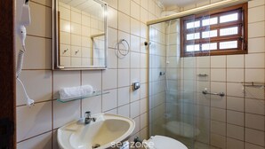 Un baño con lavamanos, inodoro y cabina de ducha de vidrio.