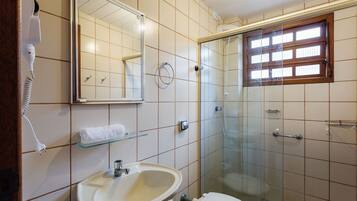 Un baño con lavamanos, inodoro y cabina de ducha de vidrio.