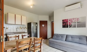 A compact living space with a kitchenette, dining area, and a sofa. - Charming Apt 270m From the Beach Stcy102 (Florianópolis)